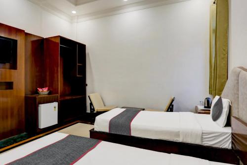 una camera d'albergo con due letti e una sedia di Townhouse Hotel Selaqui Inn a Jhājra