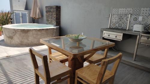 ein Esszimmer mit einem Tisch, Stühlen und einer Badewanne in der Unterkunft Studios V19 in Colima