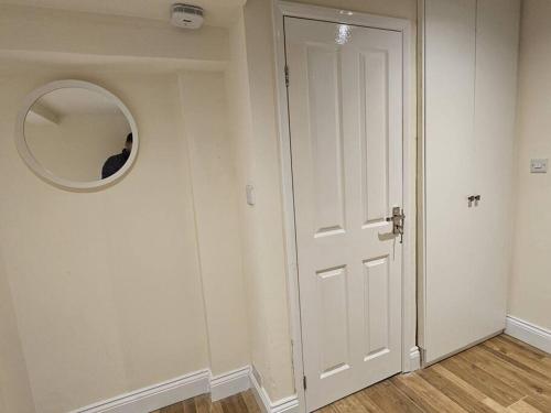 a room with a white door and a mirror at Entire en-suite flat in Windsor home with free parking in Windsor