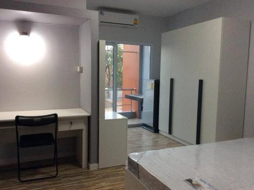 a kitchen with a table and a chair in a room at R2 Apartment Service in Nakhon Ratchasima