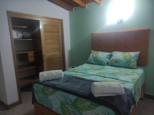 a bedroom with a bed with a wooden head board at Excellent House (Laureles) Jacuzzi and 6 Rooms in Medellín