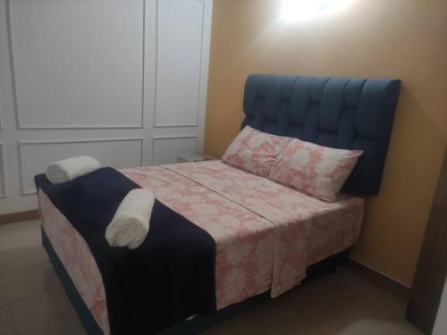 a bed with a blue headboard in a bedroom at Excellent House (Laureles) Jacuzzi and 6 Rooms in Medellín