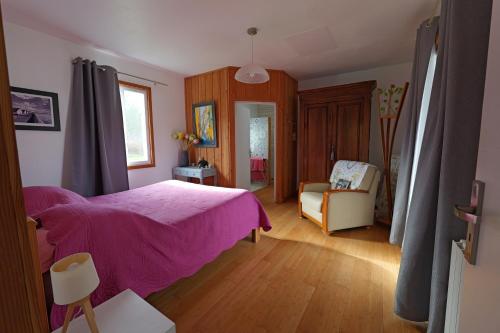 una camera con letto rosa e sedia di Les Cardaires a Grignols