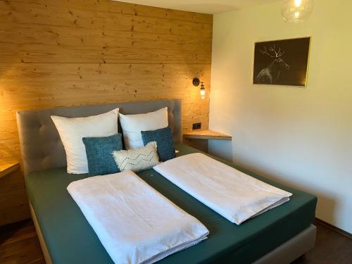 een slaapkamer met een bed met witte lakens en blauwe kussens bij Bergromantik Apartments Fritzenlehen in Berchtesgaden