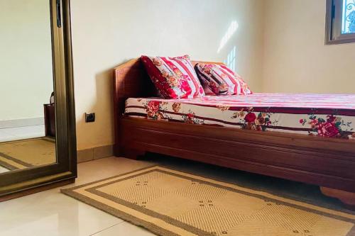 a bedroom with a bed with a mirror and a rug at Independent apartment in a villa in Ouagadougou