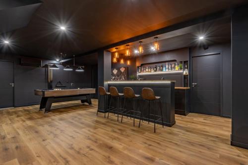 a bar with a ping pong table and stools at Villa 15 personnes - Piscine - Jacuzzi - Clim - Bar - Billard - Cinéma - Vue Panoramique in Esperce