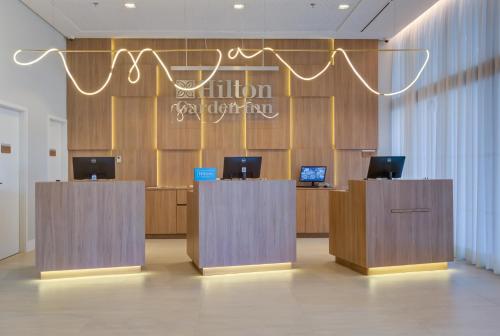 a lobby with two reception desks with computers on them at Hilton Garden Inn São José do Rio Preto in Sao Jose do Rio Preto