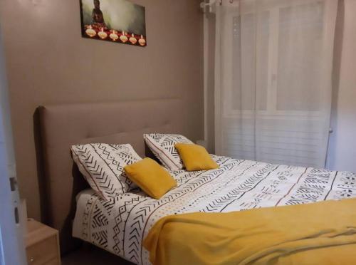 a bedroom with a bed with two yellow pillows at Le jardin d'eden in Lourdes