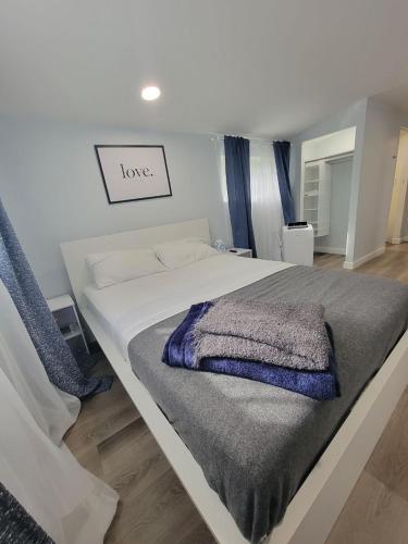 sypialnia z dużym białym łóżkiem z kocem w obiekcie Work, Rest and Play: WiFi, TV and Backyard Bliss w mieście North Miami Beach
