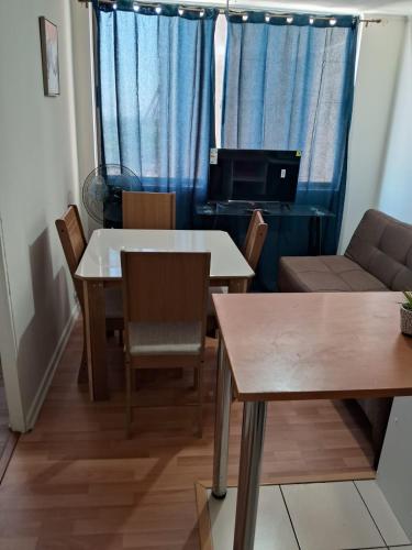 uma sala de estar com uma mesa e cadeiras e um sofá em Disfruta de un tranquilo departamento en el centro a pasos del Hipodromo em Santiago