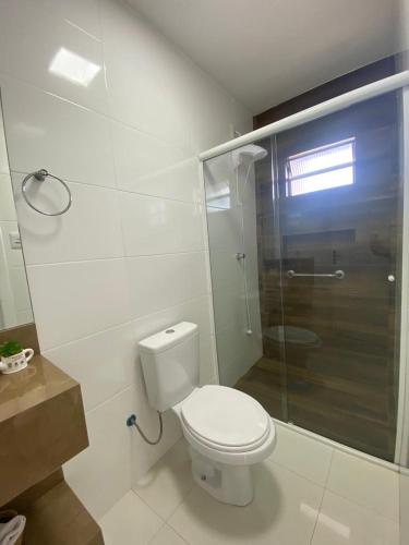 uma casa de banho com um WC e uma cabina de duche em vidro. em Residencial Mariano 5 em Florianópolis