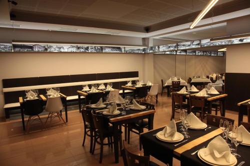 un restaurant avec des tables et des chaises avec des chapeaux. dans l'établissement Hotel San Cibrao, à San Ciprián de Viñas