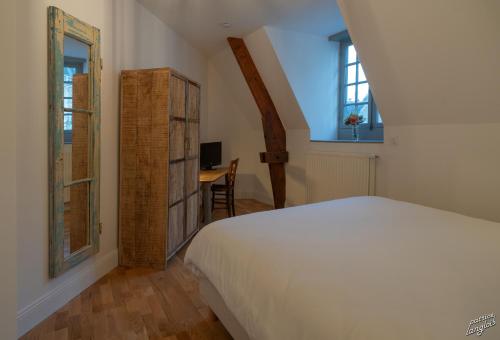 a bedroom with a bed and a desk and a window at Suite "États Généraux" face au château - LES SUITES DE BLOIS - 4 étoiles in Blois