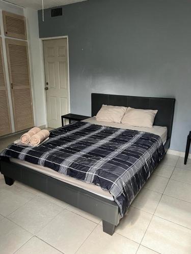 a bedroom with a bed with a black and white comforter at Habitación céntrica y espaciosa con A/A in Panama City