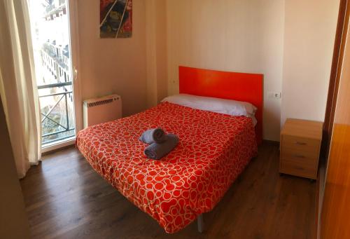 Un dormitorio con una cama roja con un osito de peluche. en Sierra Nevada Serraneu Vistas, en Sierra Nevada