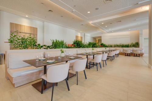 a dining room with tables and chairs and plants at Hilton Garden Inn São José do Rio Preto in Sao Jose do Rio Preto