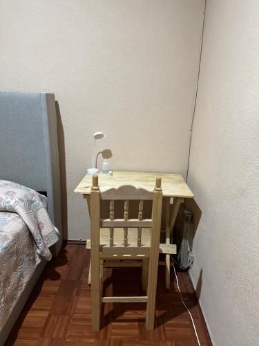 una mesa de madera con una lámpara junto a una cama en Casa Yolcatl en Ciudad de México