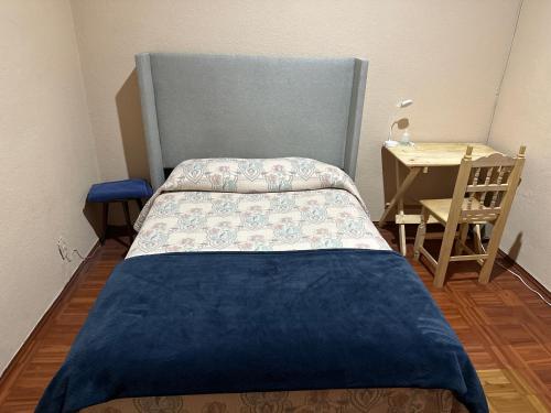 Dormitorio pequeño con cama y mesa en Casa Yolcatl en Ciudad de México