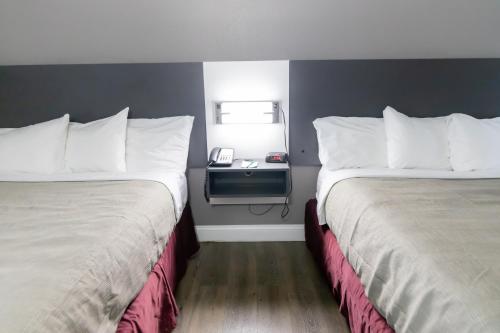 a hotel room with two beds and a telephone at Quality Inn Carrollton Medical Center in Carrollton