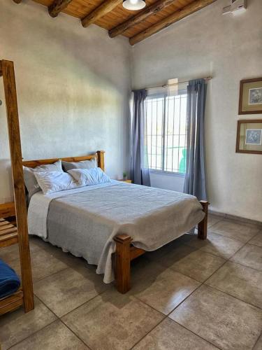 Un dormitorio con una cama grande con ventana. en Cabañas Entre Lagos San Rafael, en San Rafael