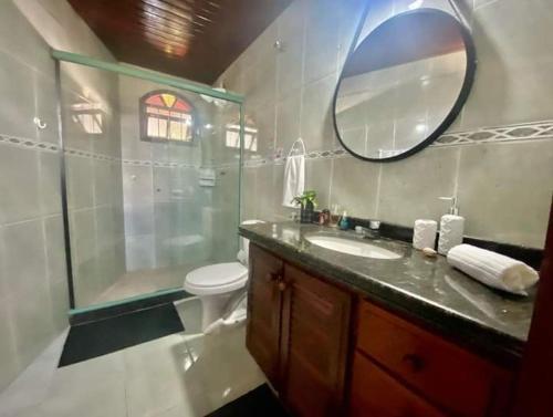 uma casa de banho com um chuveiro, um lavatório e um espelho. em Aconchego de geriba em Búzios