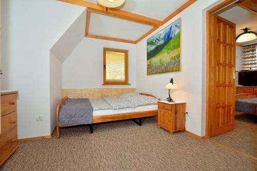 1 dormitorio con 1 cama, vestidor y ventana en Willa Świerk - Panorama Tatr en Zakopane