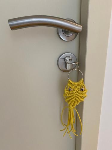 a yellow object is hanging on a door handle at Les Chambres des 3 Chouettes in Sepx