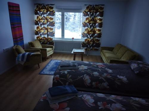 a bedroom with a bed and a couch and a window at Saarnimaja in Hämeenlinna