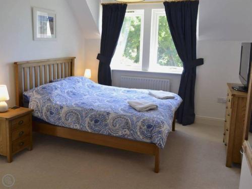 una camera da letto con un letto con una coperta blu e una finestra di Best of both worlds! a Truro