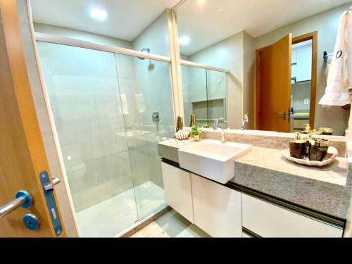 een badkamer met een douche, een wastafel en een spiegel bij Flat Eco Resort Praia Carneiros, Tamandaré. Porto dos corais 202 in Tamandaré
