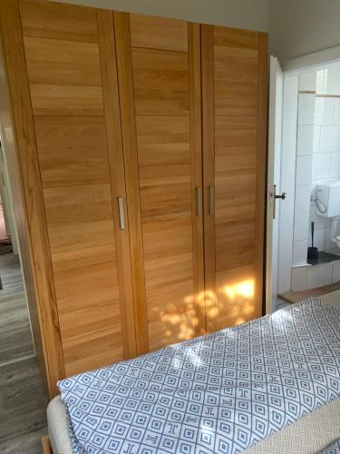 een slaapkamer met een houten deur en een bed bij Schöne Ferienwohnung/Pendlerwohnung in Uelzen