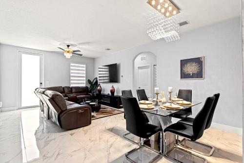 ein Wohnzimmer mit einem Tisch und einem Sofa in der Unterkunft Lux Backyard/Heated Pool/Everglades/Speedway/Keys! in Miami