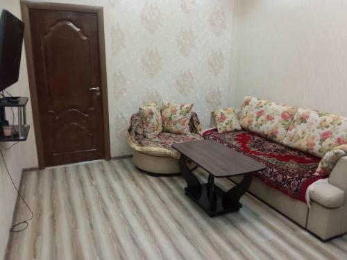 a living room with a couch and a table at Apartment in the 7th Microdistrict in Bishkek
