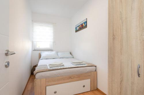 a small bedroom with a small bed in a room at Tom's House Njivice in Njivice