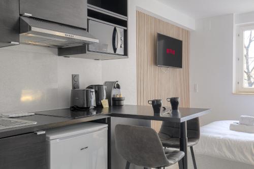a kitchen with a black counter top and a bed at Lionne-Stade du Lou in Lyon