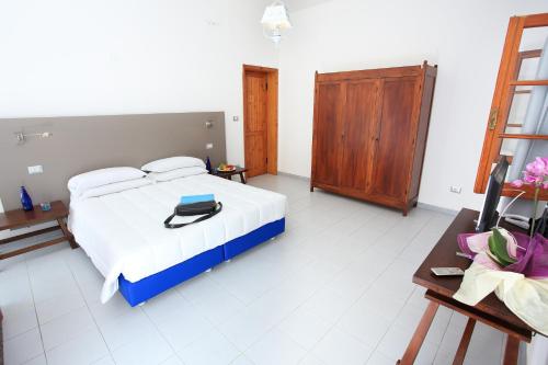a bedroom with a bed and a wooden cabinet at Hotel Meli in Castelsardo
