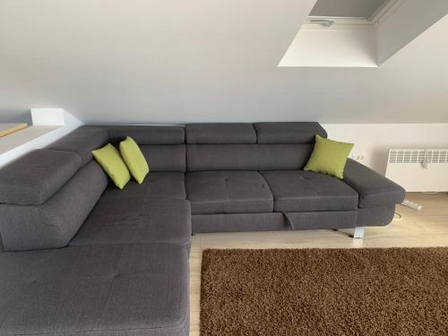 a gray couch with two yellow pillows in a living room at Tom's House Njivice in Njivice
