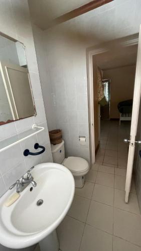 a bathroom with a white sink and a toilet at Ya mon inn in Negril