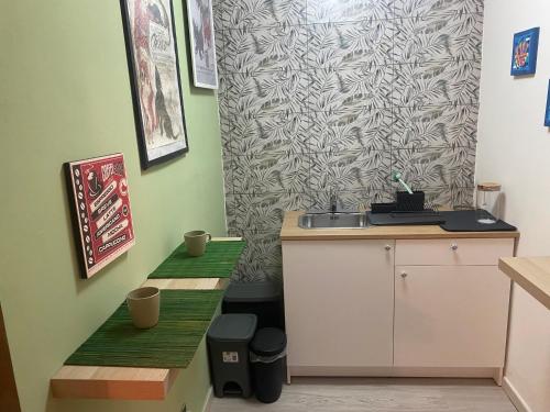 eine Küche mit Grünflächen, einer Spüle und einer Wand in der Unterkunft Il Fico Storto in Pollena Trocchia
