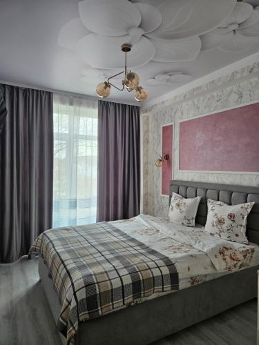 a bedroom with a large bed with a ceiling at Central Apartments Chisinau in Chişinău