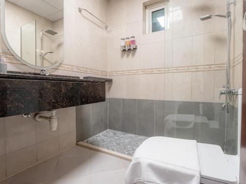 a bathroom with a shower and a mirror at In the Heart of the Marina, by the beach! in Dubai