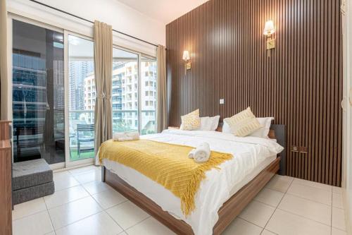 a bedroom with a large bed and a large window at In the Heart of the Marina, by the beach! in Dubai