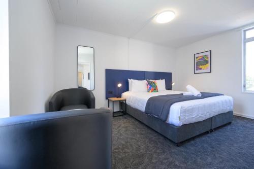 a bedroom with a bed and a desk and a chair at Urban Lounge Sleepery in Rotorua