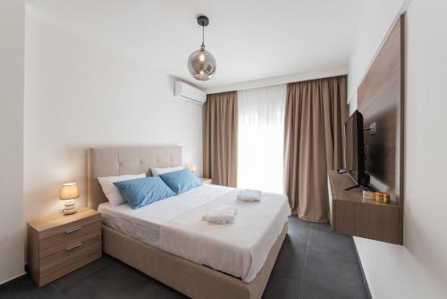 um quarto com uma cama grande e uma televisão em Sansevieria Central em Tessalônica