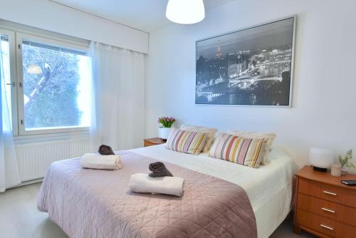 a bedroom with a bed with two cat towels on it at Cozy 93m² Townhouse with Large Terrace & Sauna in Turku