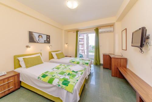 ein Hotelzimmer mit zwei Betten und einem Fernseher in der Unterkunft Hotel Novi in Herceg-Novi