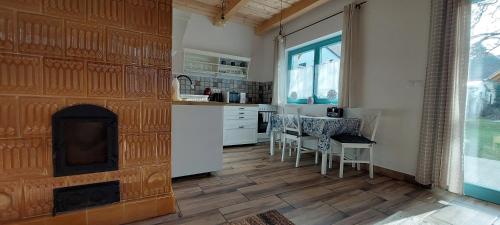 a kitchen with a fireplace and a table and chairs at Odú Vendégház in Badacsonytördemic