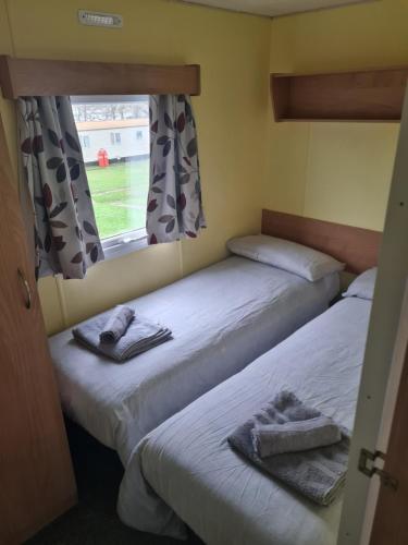 2 camas en una habitación pequeña con ventana en 31 Beachlands en Cowes