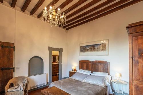 a bedroom with a bed and a chandelier at Wohnung auf der "Bel etage" in Pescia