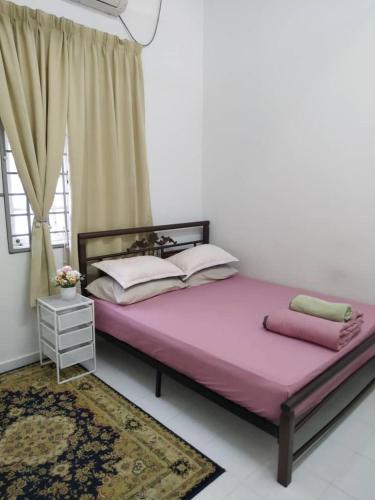 a bedroom with a large pink bed with a window at Homestay Seri Aman Pasir Puteh 